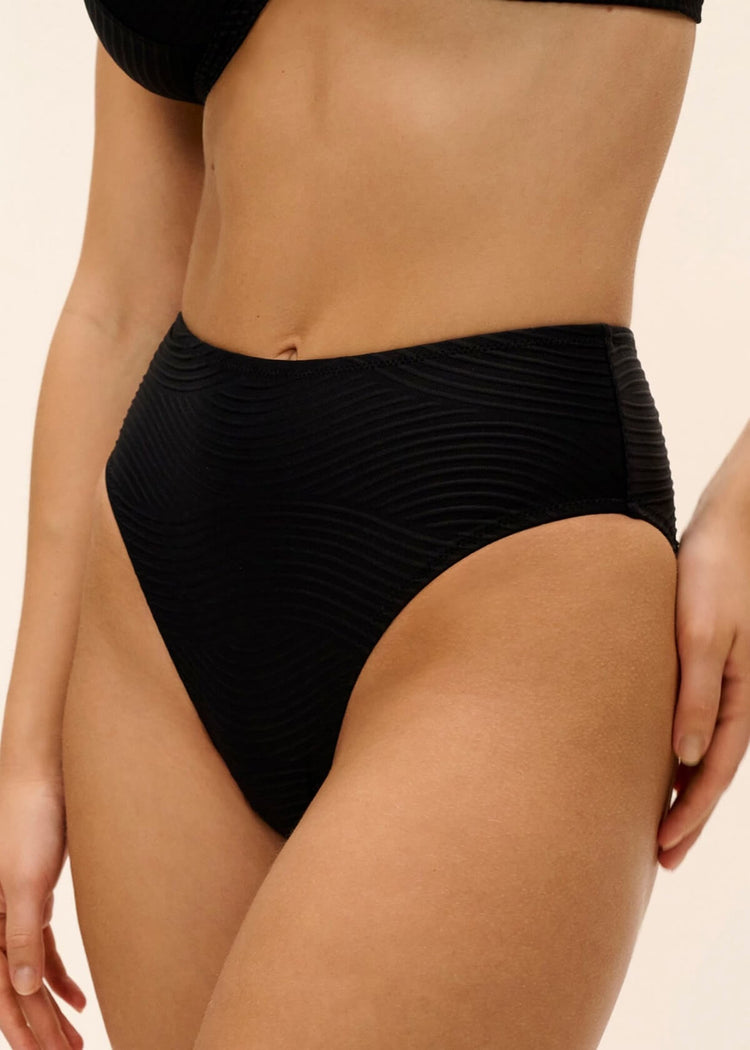 Model in Cala Cuba High Waist Bikini Broekje Black Sands zijkant